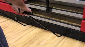 staff manually opening school bleachers with handle